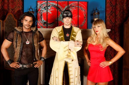Captura de pantalla de The Pick-Up Artist de VH1. Matador, vestido con una camisa de malla y jeans, está de pie junto a Mystery con un gorro, gafas protectoras y un abrigo de brocado en el centro, con una mujer rubia vestida de rojo a la derecha.