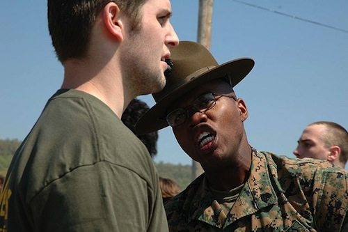 African American Marine Corps drill instructor yelling at recruit