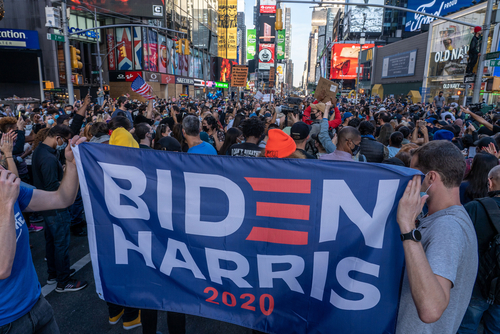 People with signs celebrate Biden / Harris ticket election victory in Times Square on November 7, 2020 in New York City.