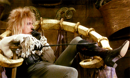 animated gif of David Bowie in Labyrinth, lounging in a chair and tapping his thigh with a riding crop