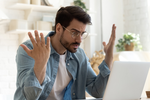 Angry frustrated annoyed young adult man consumer feel rage looking at computer notebook screen