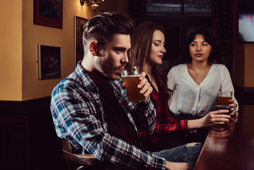 Friends sitting in a pub, enjoying drinks at the bar