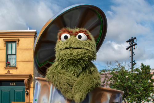 Oscar the Grouch coming out of his garbage can