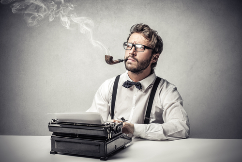 white man in glasses, suspenders, button down shirt and bow tie, smoking a pipe and sitting in front of a vintage typewriter, looking pensive