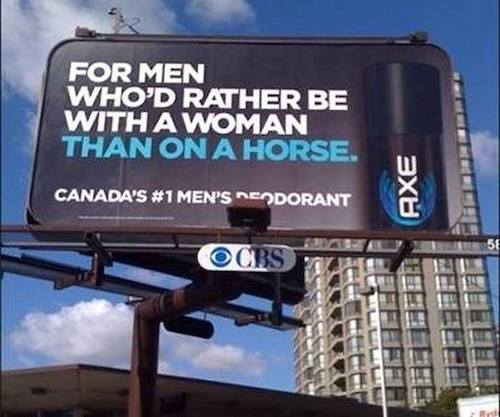 Picture of a billboard advertising Axe deodorant in Canada. Text reads: "FOR MEN WHO'D RATHER BE WITH A WOMAN THAN ON A HORSE CANADA'S #1 MEN'S DEODORANT"