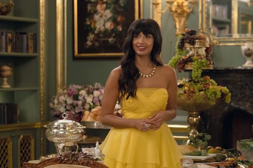 Jameela Jamil como Tahani en "The Good Place" con un vestido amarillo y de pie en una lujosa mansión
