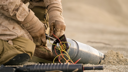 Close-up shot of Soldier Defusing a Bomb by Cutting a Wire During Military Operation in Desert Environment